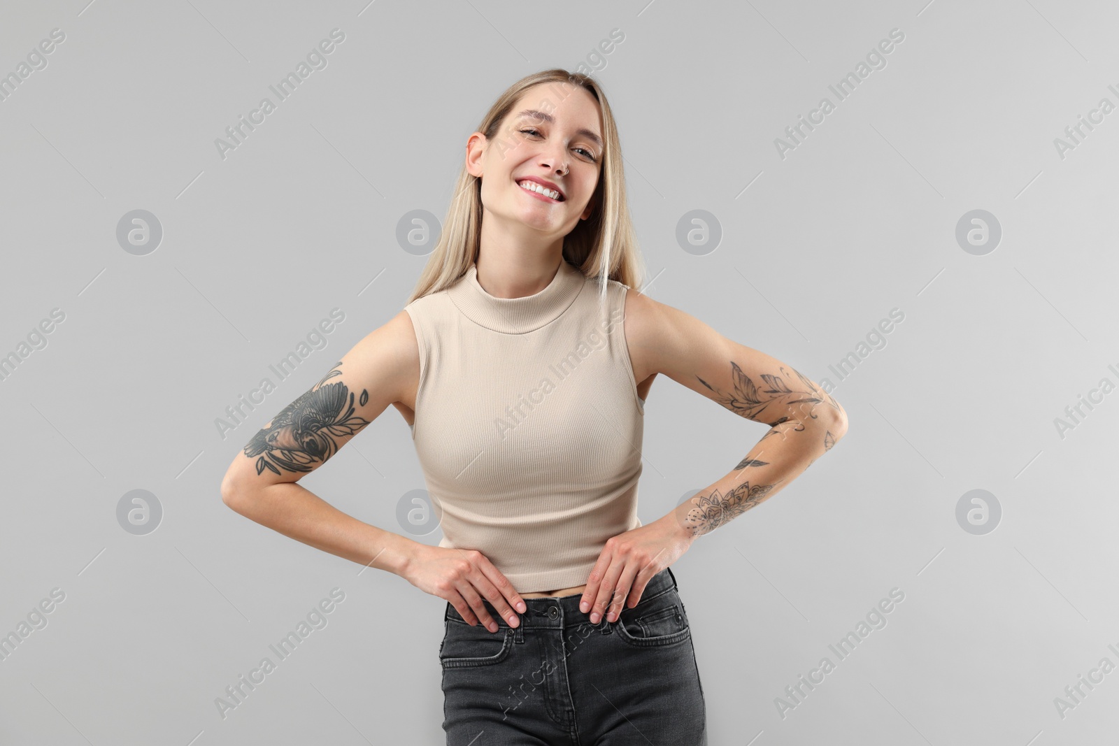 Photo of Portrait of beautiful tattooed woman on gray background