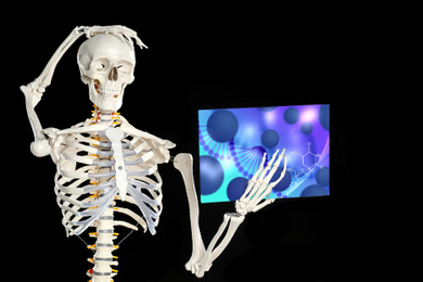Image of Artificial human skeleton with illustration of virus on black background