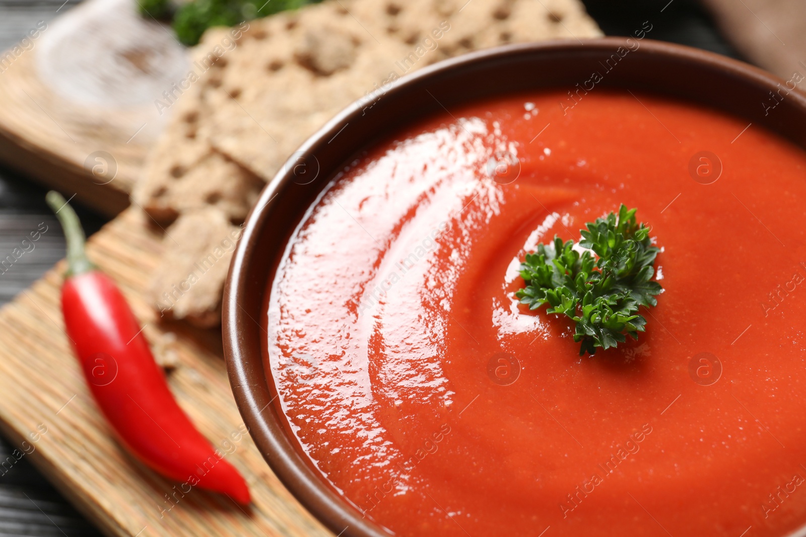 Photo of Bowl with fresh homemade tomato soup on table, closeup