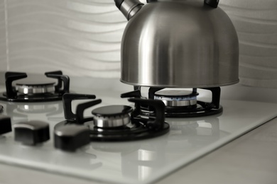 Photo of Steel kettle with whistle on modern gas stove