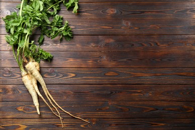 Tasty fresh ripe parsnips on wooden table, flat lay. Space for text