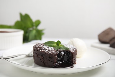Photo of Delicious fresh fondant with hot chocolate, mint and ice cream served on white table