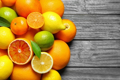 Photo of Flat lay composition with different citrus fruits and space for text on wooden background