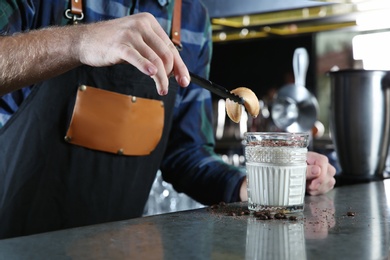 Photo of Barman making White Russian cocktail at counter in pub, closeup. Space for text