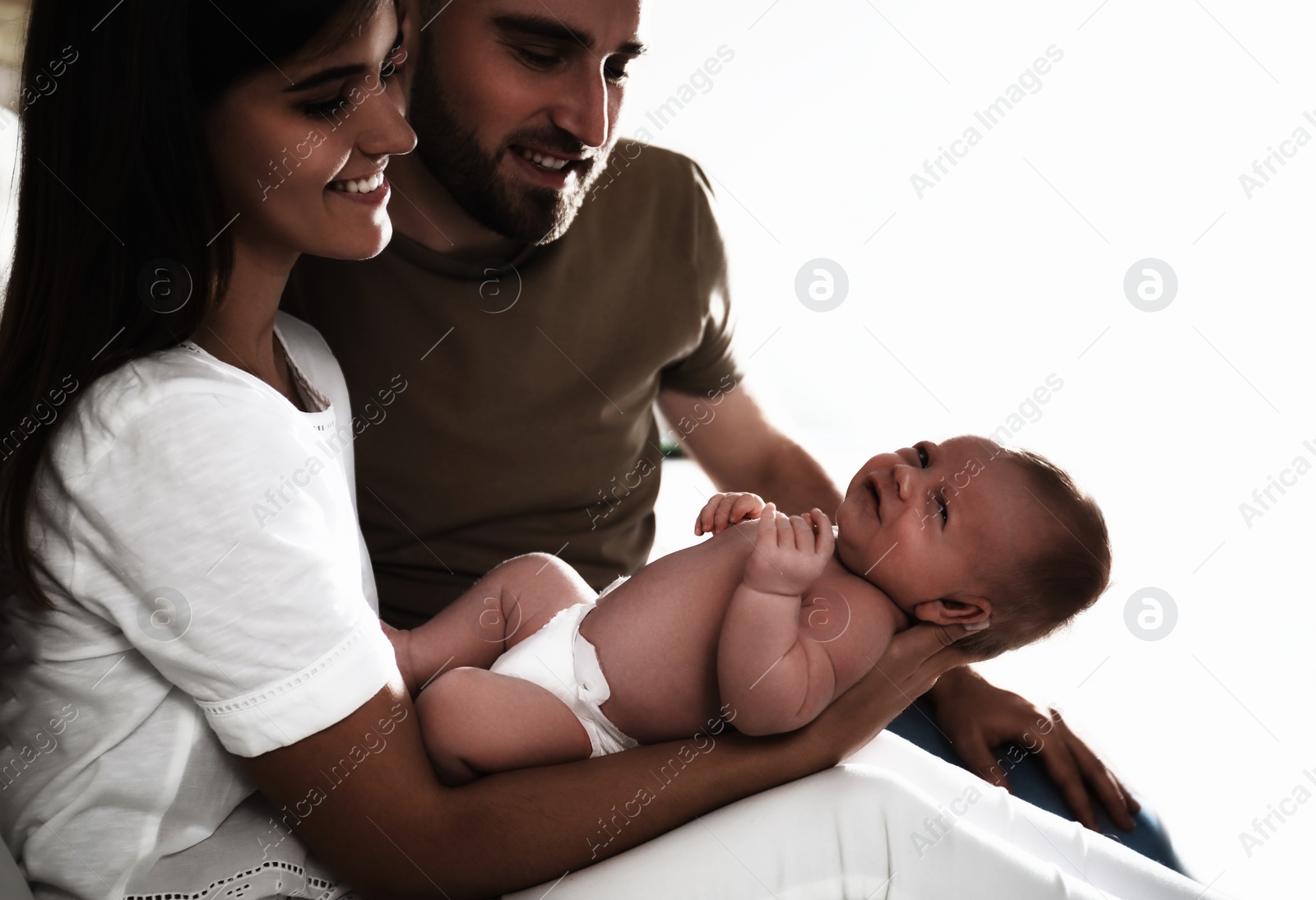 Image of Happy couple with their newborn baby on white background