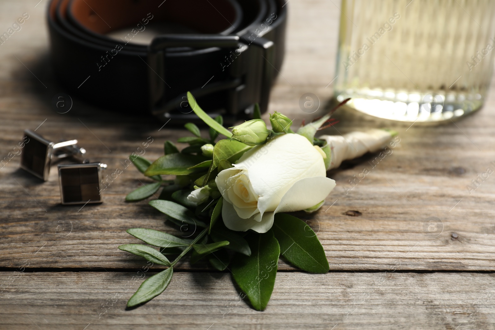 Photo of Wedding stuff. Composition with stylish boutonniere on wooden table, closeup