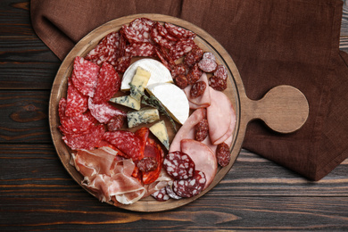 Tasty ham and other delicacies served on wooden table, top view