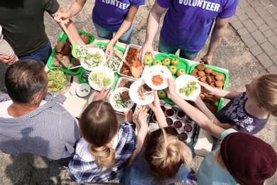 Photo of Volunteers serving food for poor people outdoors, above view