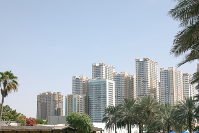 Photo of AJMAN, UNITED ARAB EMIRATES - NOVEMBER 04, 2018: Landscape with modern multi-storey buildings on sunny day