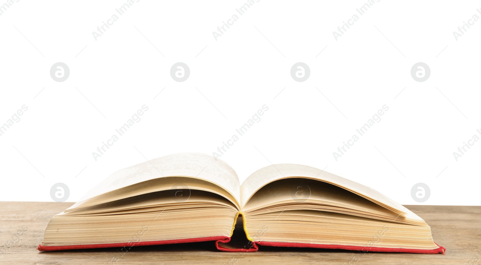 Photo of Open book on wooden table against white background