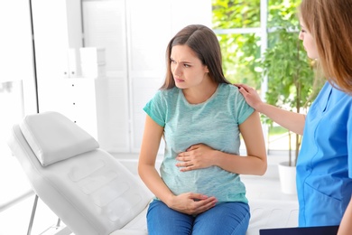 Photo of Young pregnant woman with depression and her doctor in clinic