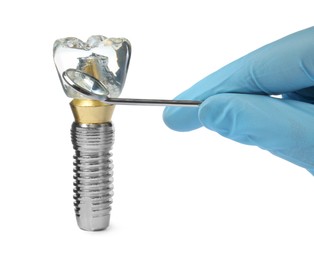 Dentist with mirror pointing at educational model of dental implant on white background, closeup