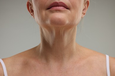 Photo of Mature woman with healthy skin on grey background, closeup