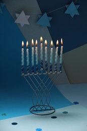 Photo of Hanukkah celebration. Menorah with burning candles on color background