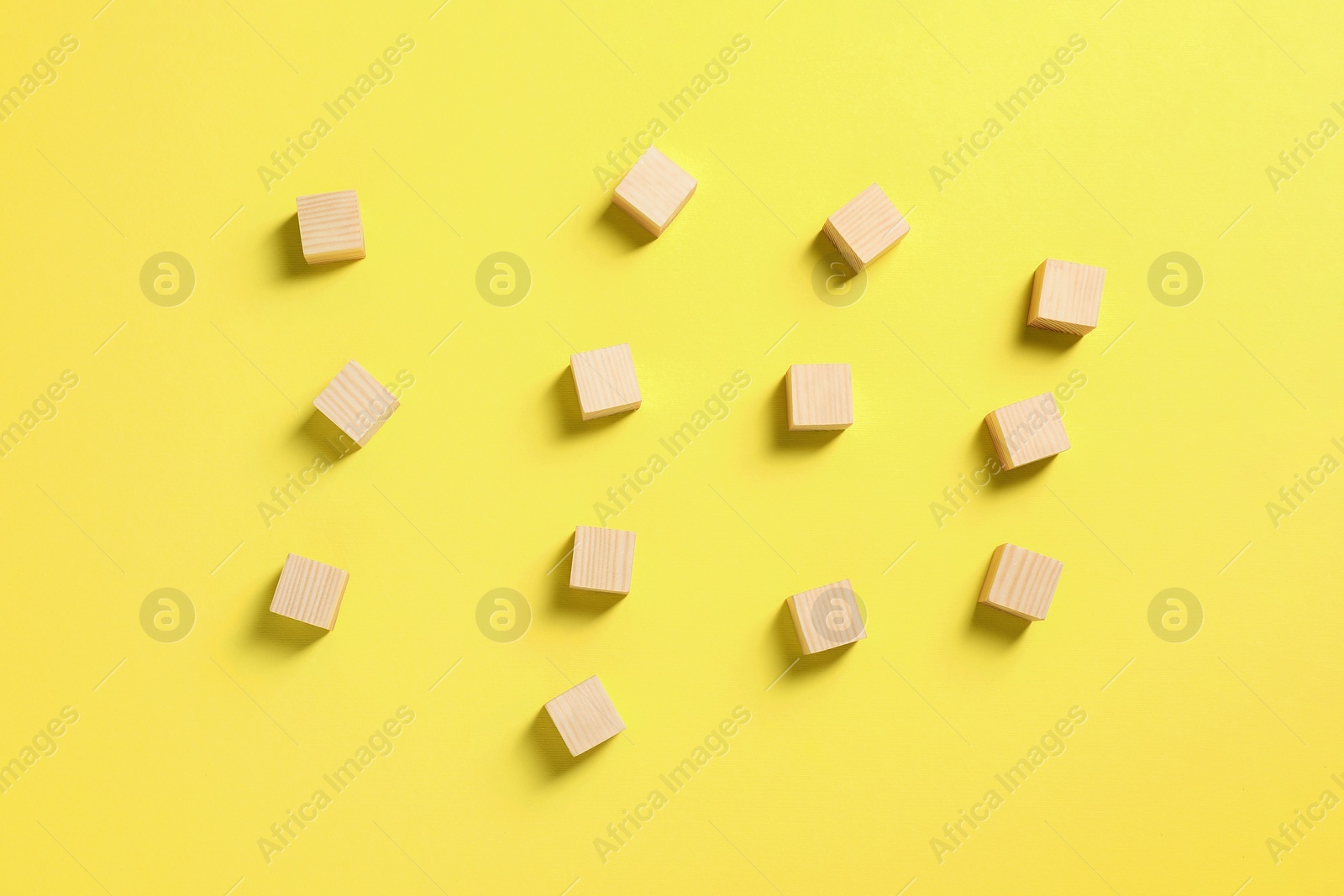 Photo of Blank wooden cubes on yellow background, flat lay