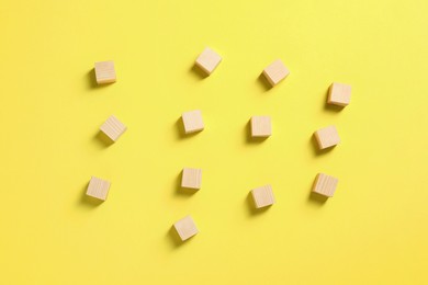 Photo of Blank wooden cubes on yellow background, flat lay