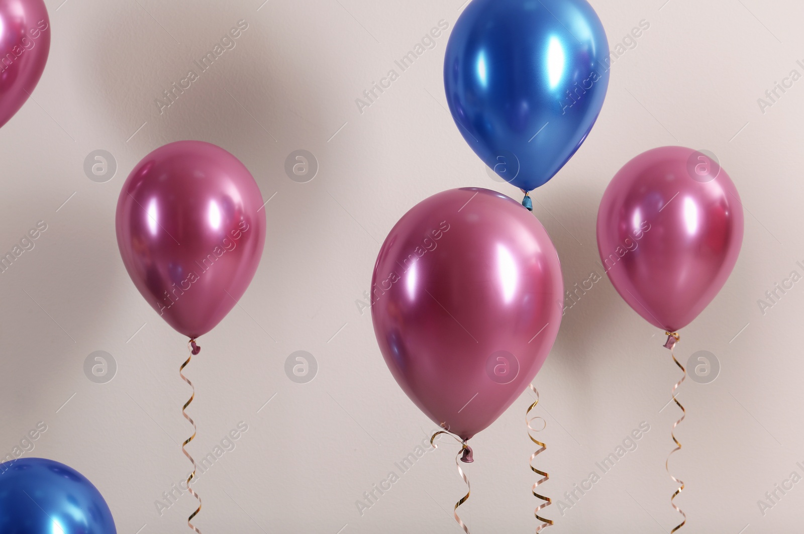 Photo of Color balloons with ribbons on white background