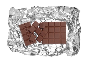 Photo of Pieces of delicious milk chocolate bars with foil isolated on white, top view