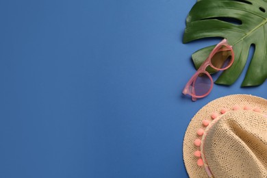 Flat lay composition with straw hat on blue background. Space for text