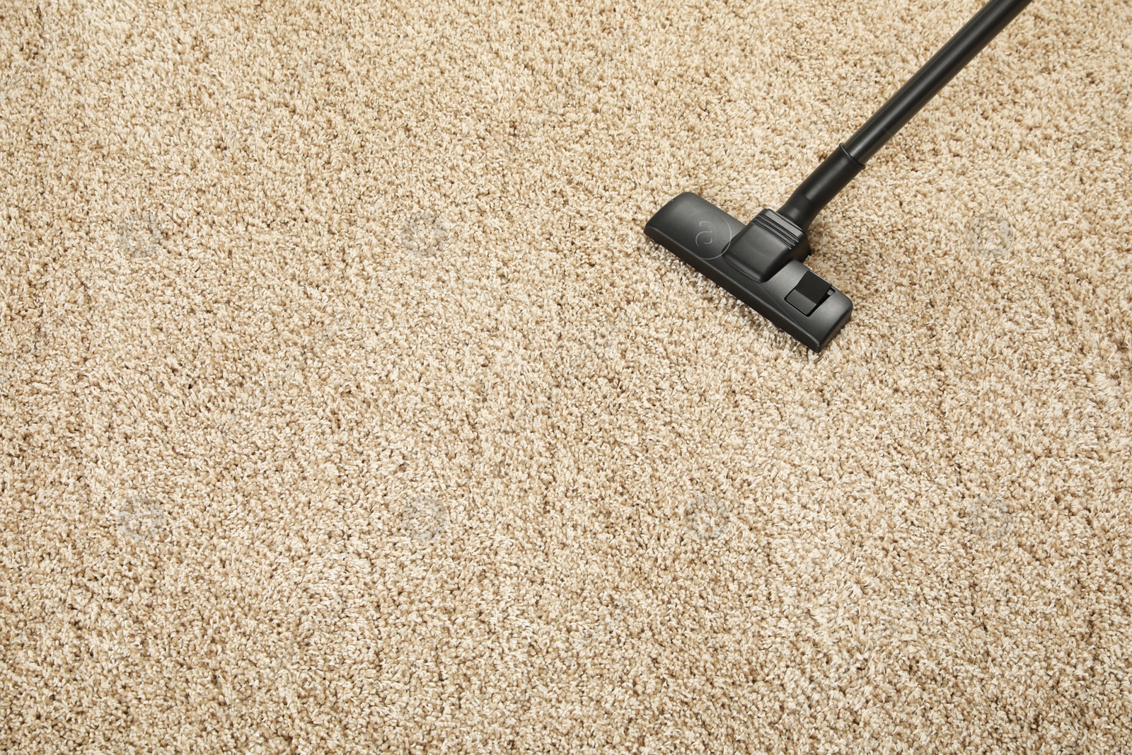 Photo of Removing dirt from beige carpet with modern vacuum cleaner, above view. Space for text