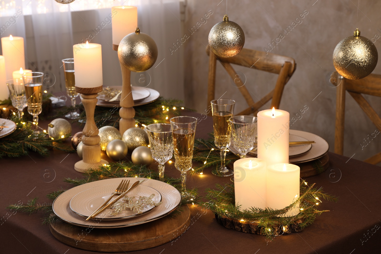 Photo of Christmas table setting with burning candles and festive decor