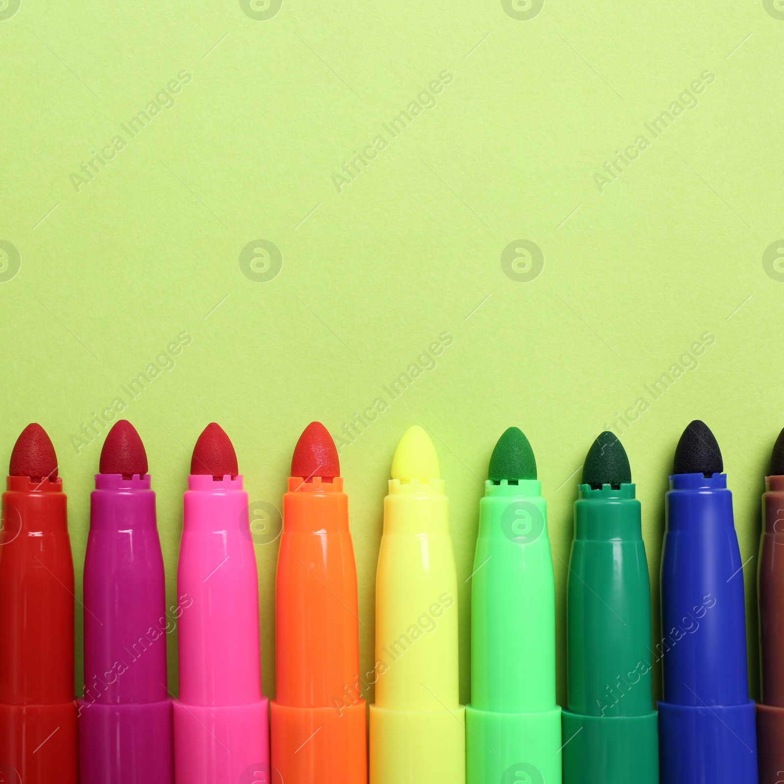 Image of Set of felt tip pens on light green background, flat lay. Space for text
