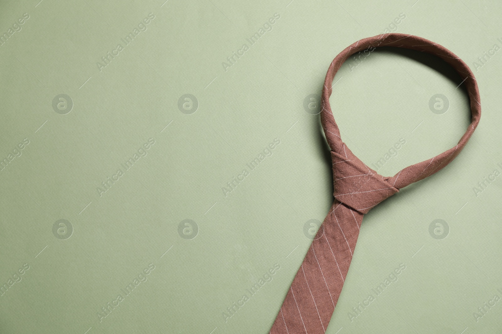 Photo of Stylish necktie on light green background, top view. Space for text