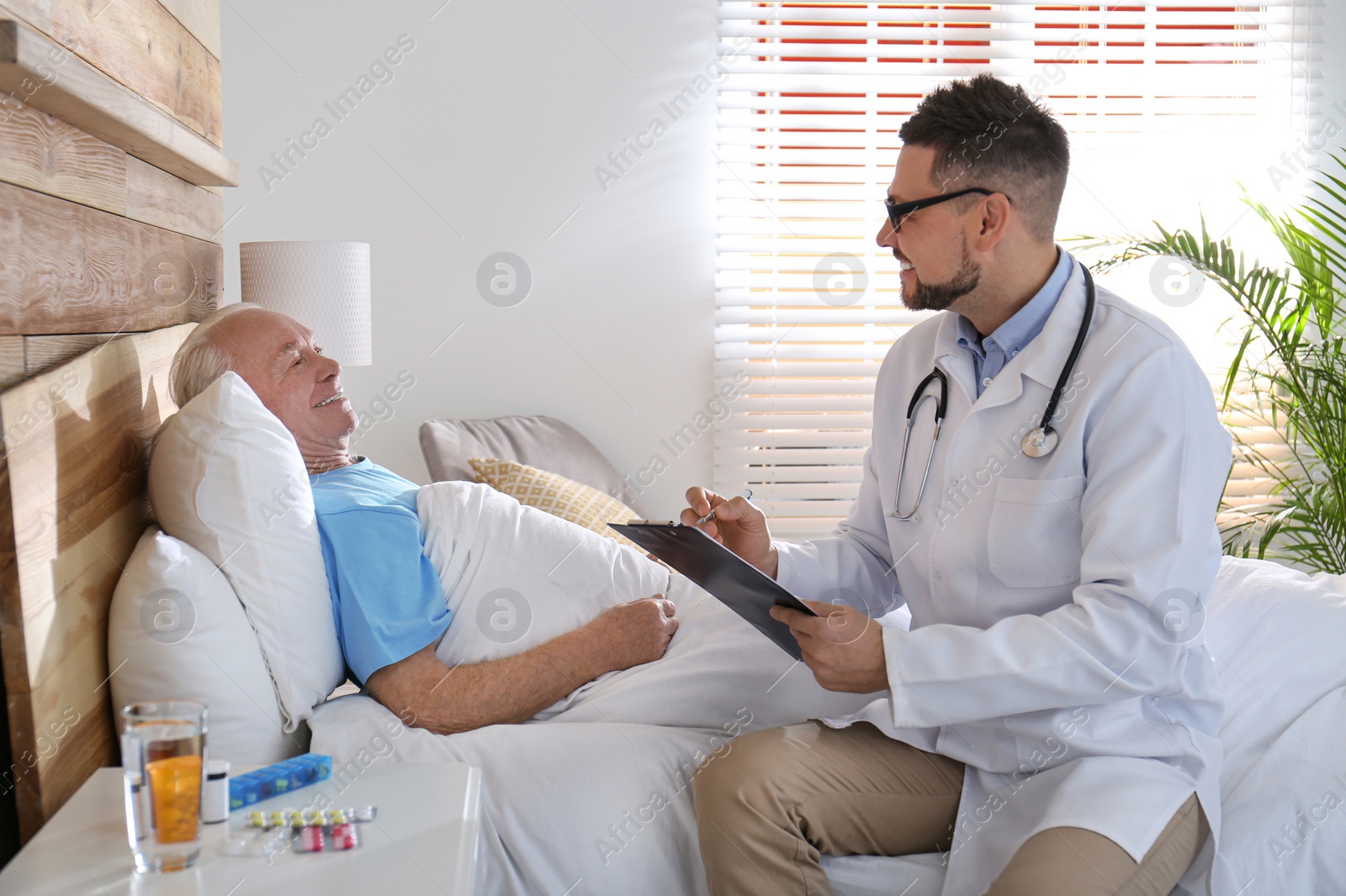 Photo of Doctor examining senior patient in modern hospital