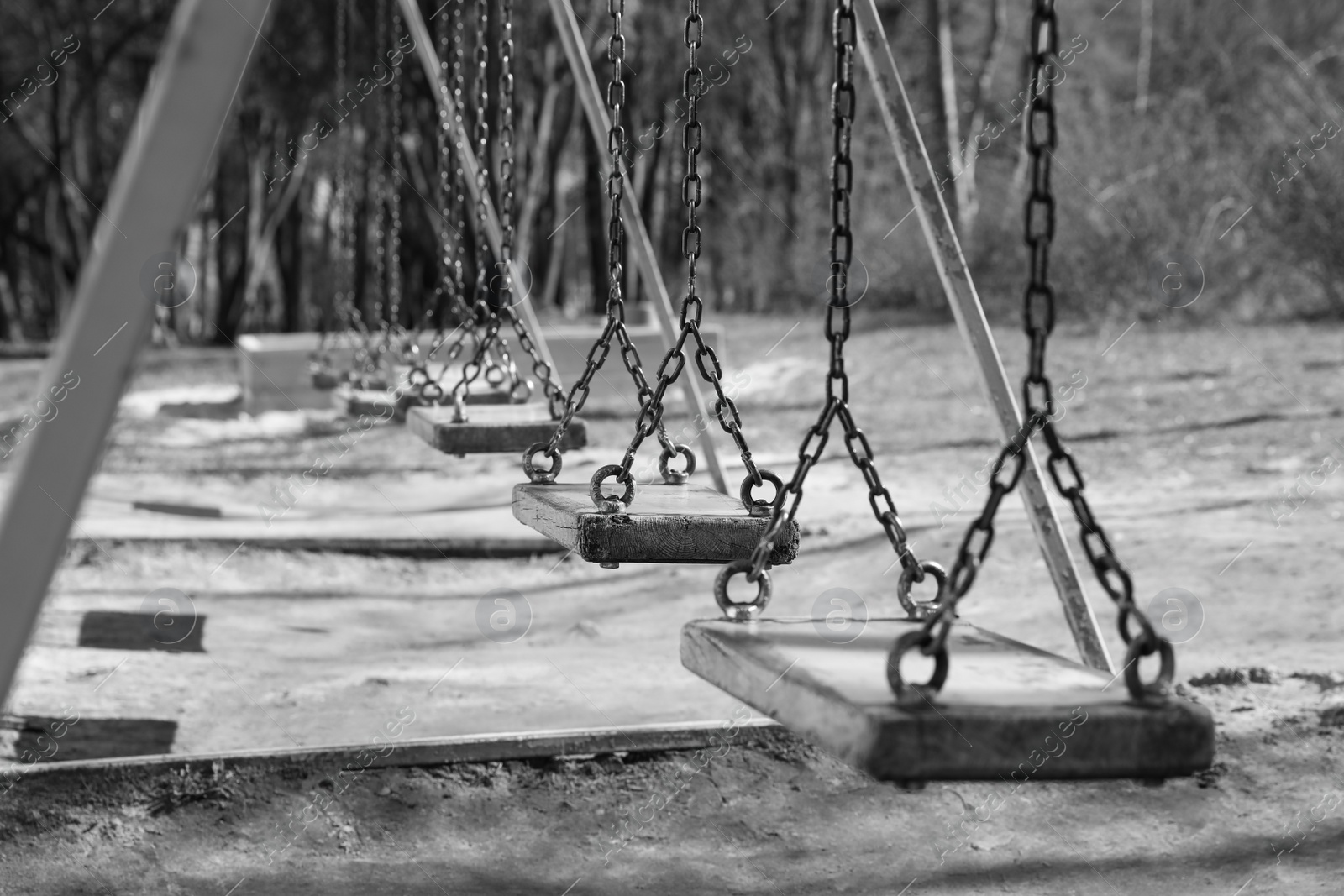 Photo of Wooden swings in park. Black and white effect