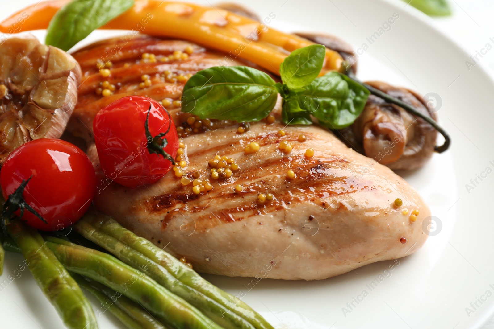 Photo of Tasty grilled chicken fillet with vegetables on plate, closeup
