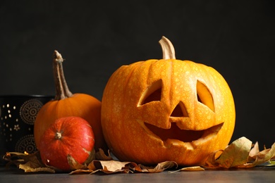 Photo of Composition with pumpkin head on dark background. Jack lantern - traditional Halloween decor