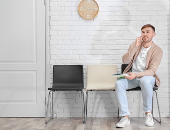 Young man waiting for job interview, indoors