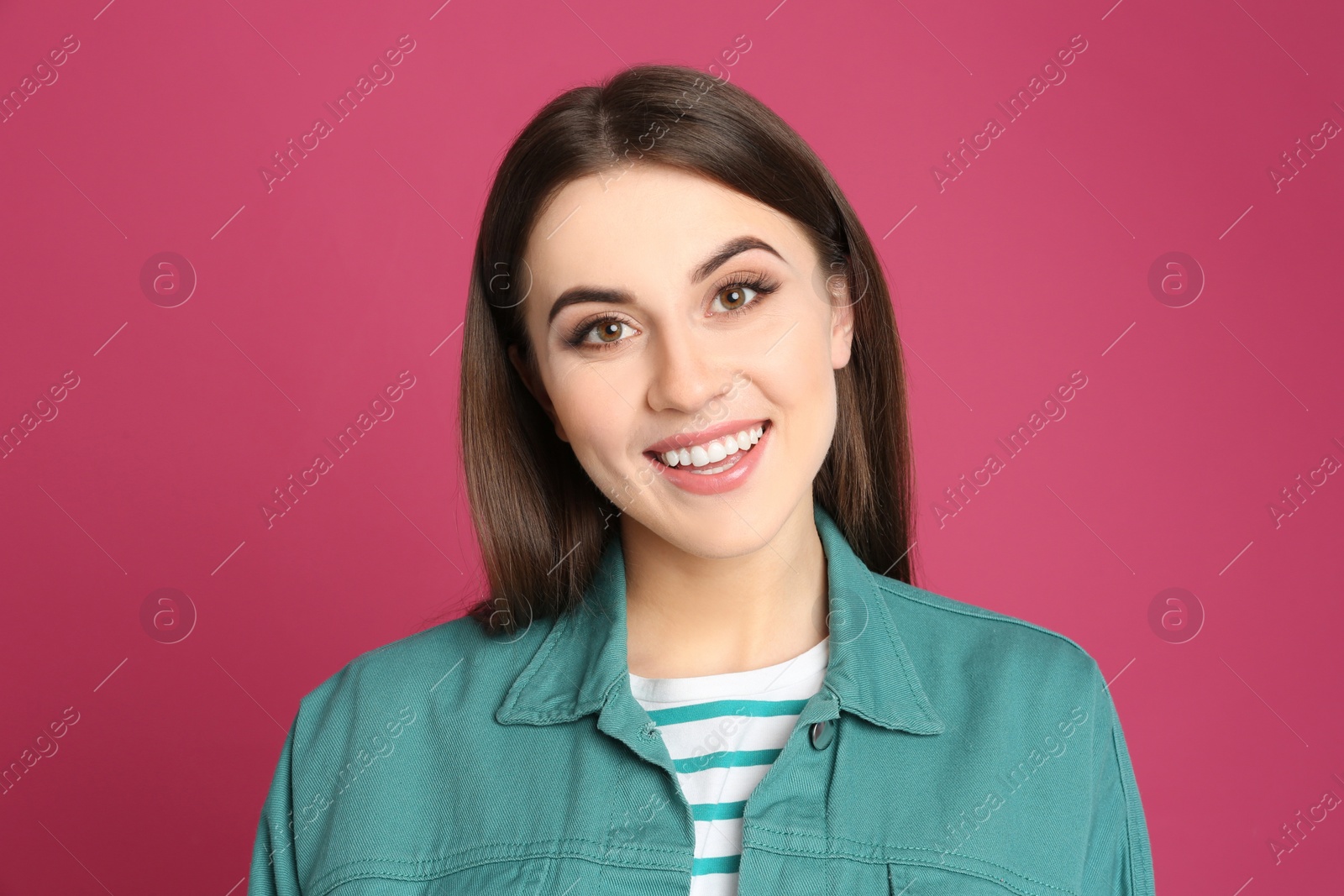 Photo of Portrait of happy young woman on pink background