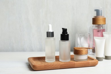 Different cosmetic products on white wooden table