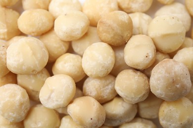 Photo of Tasty peeled Macadamia nuts as background, top view