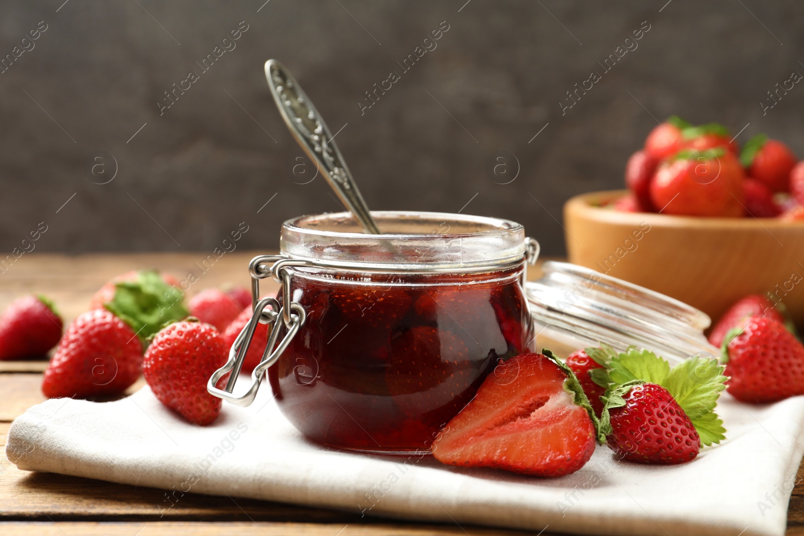 Photo of Delicious pickled strawberry jam and fresh berries on wooden table