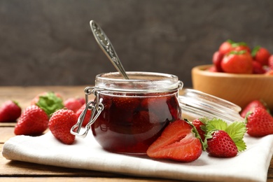 Delicious pickled strawberry jam and fresh berries on wooden table