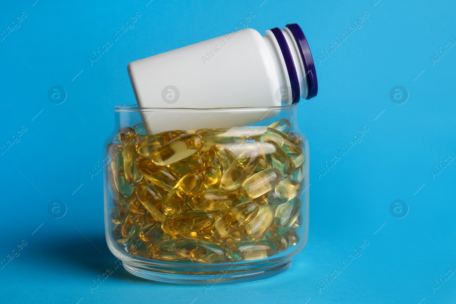 Photo of Medical bottles and pills on light blue background