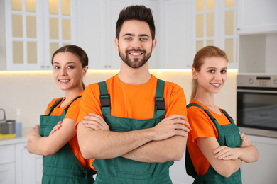 Team of professional janitors in kitchen. Cleaning service