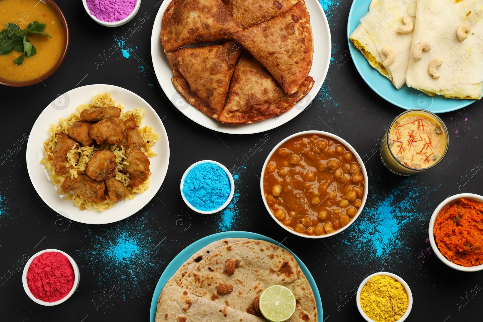 Photo of Traditional Indian food and color powders on black background, flat lay. Holi festival celebration