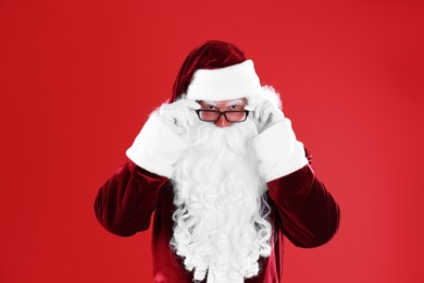 Portrait of Santa Claus with glasses on red background