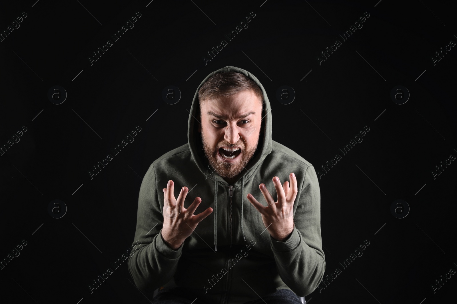 Photo of Portrait of emotional young man on black background. Personality concept