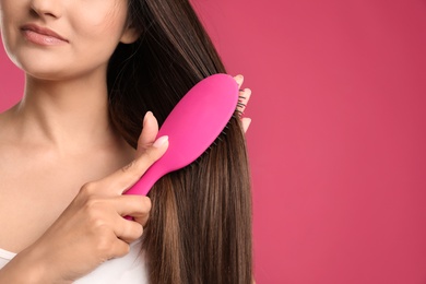 Woman with hair brush on color background, closeup. Space for text