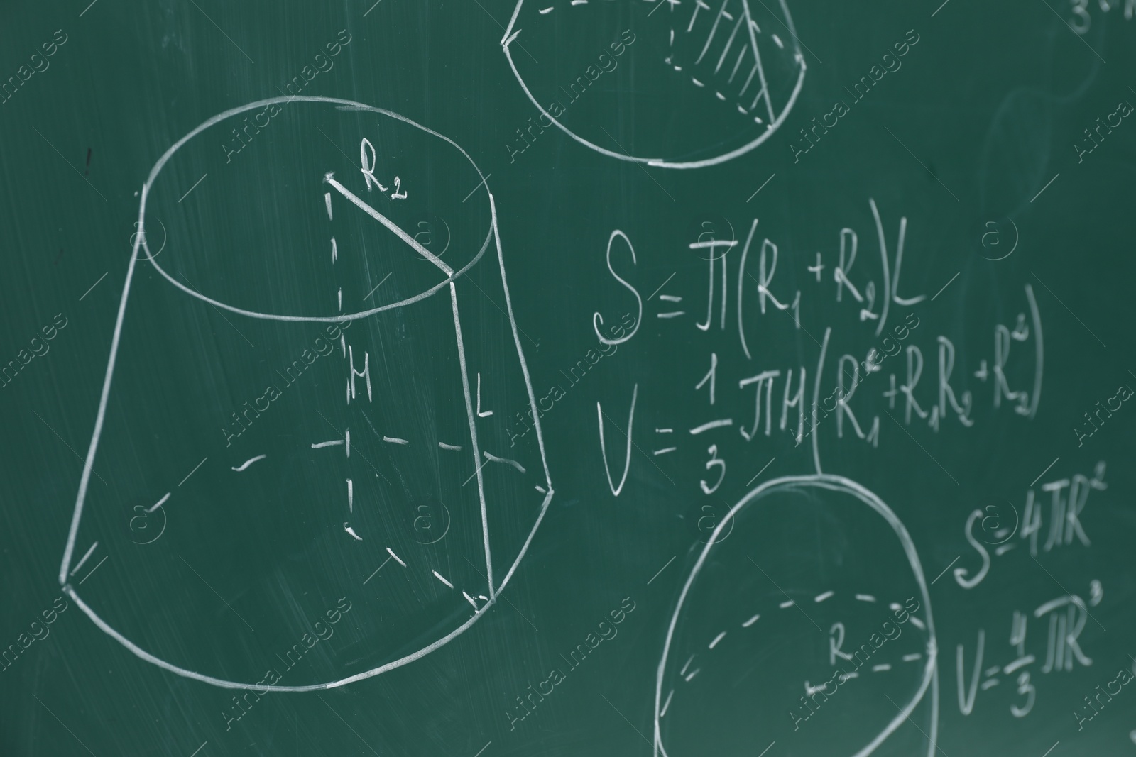 Photo of Different math formulas written with chalk on green board