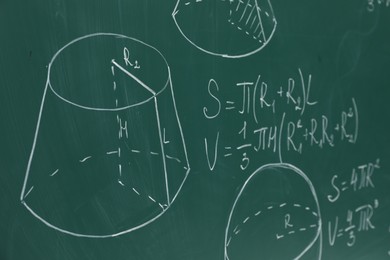Different math formulas written with chalk on green board