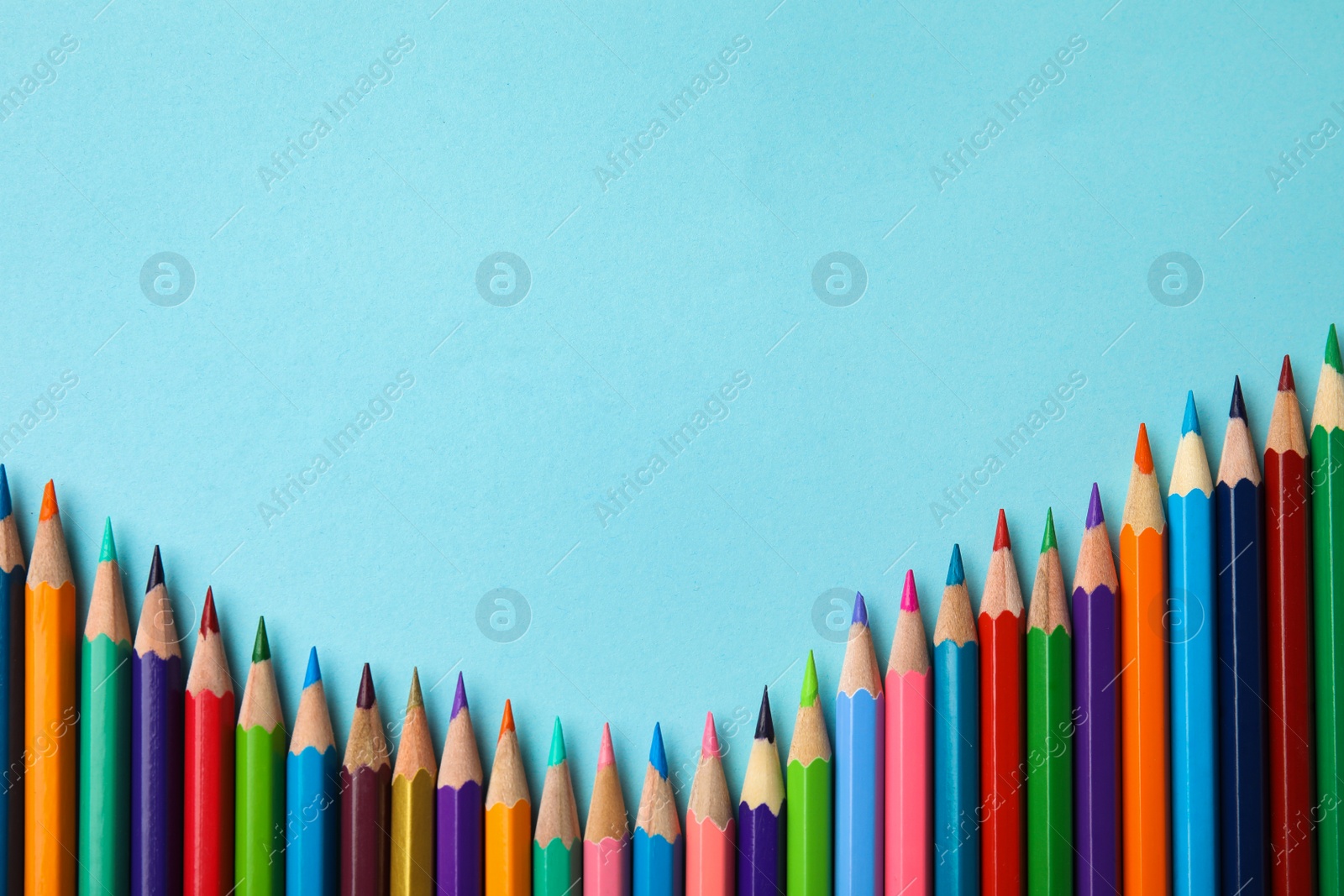 Photo of Flat lay composition with color pencils on blue background, space for text