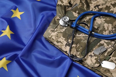 Stethoscope and military uniform on flag of European Union, above view