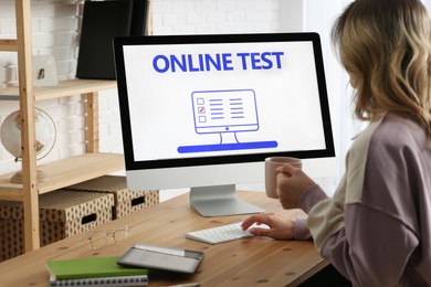 Photo of Woman taking online test on computer at desk indoors
