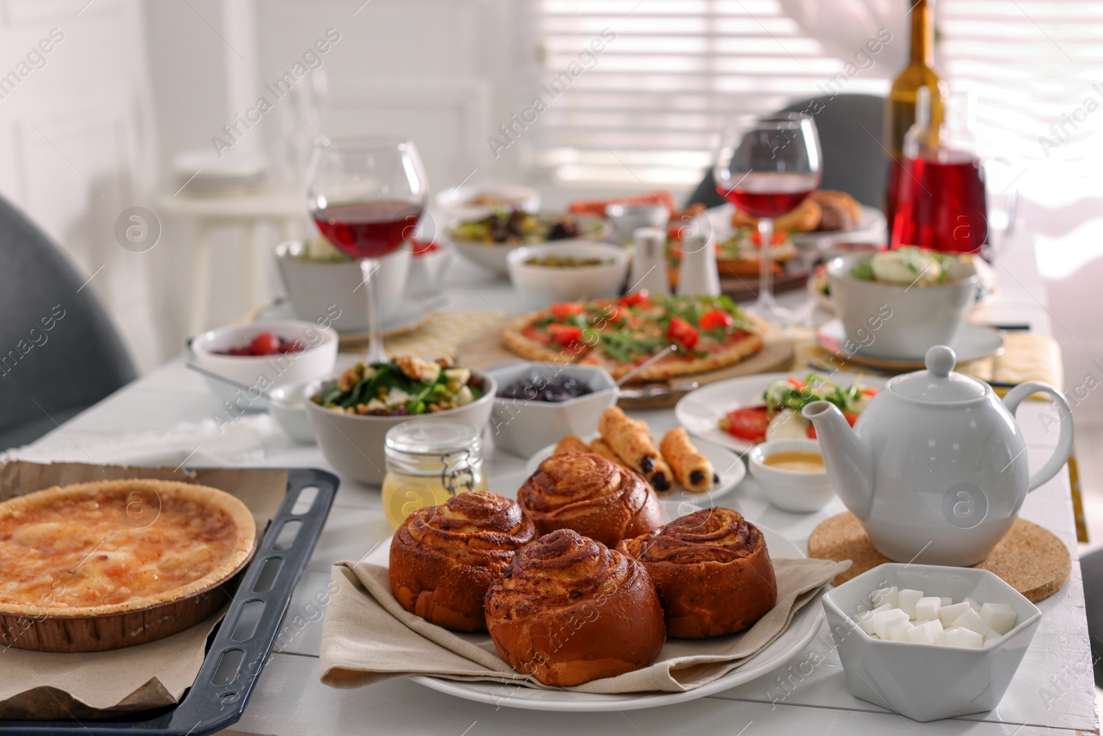 Photo of Delicious buns and many different dishes served on buffet table for brunch