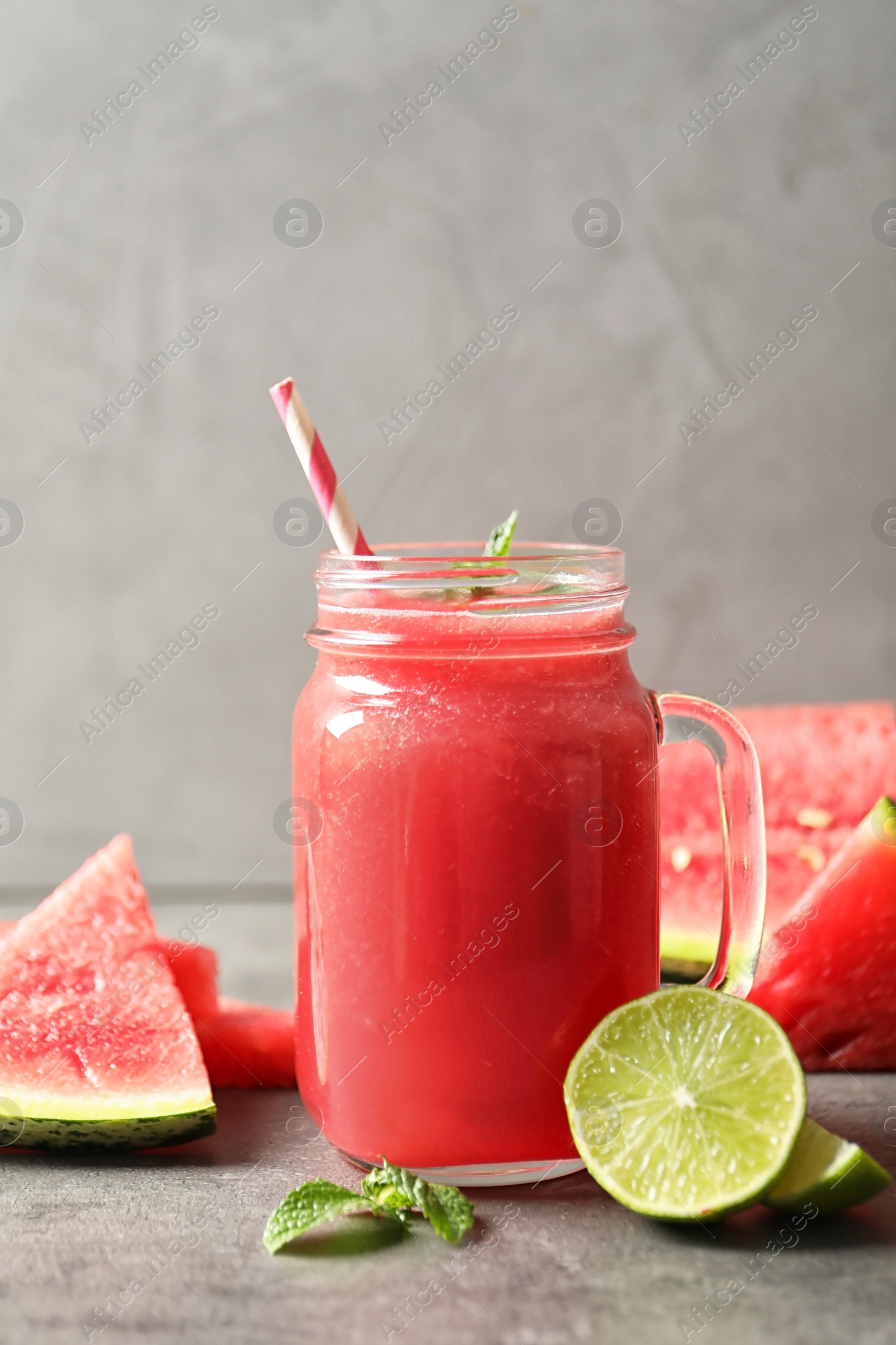 Photo of Summer watermelon drink in mason jar and sliced fruits on table